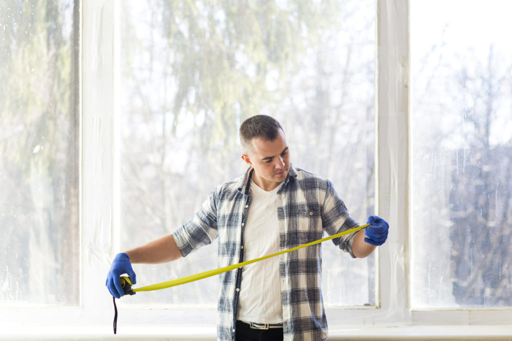 handyman measuring with a metal measuring tape