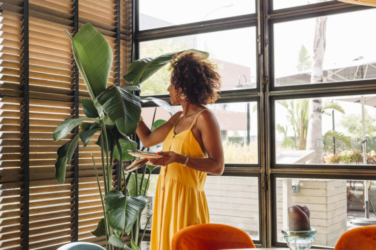 woman in yellow dress admiring decorland blinds
