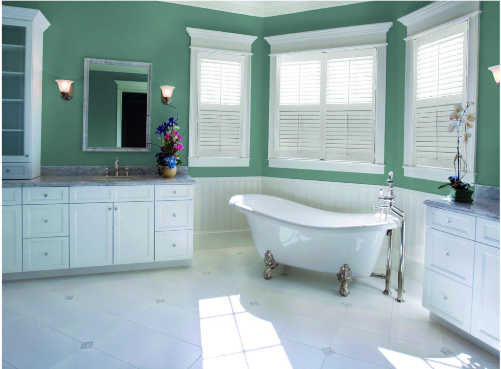 An image showing a Victorian-style free-standing bathtub and marbled counters, along with vinyl window shutters