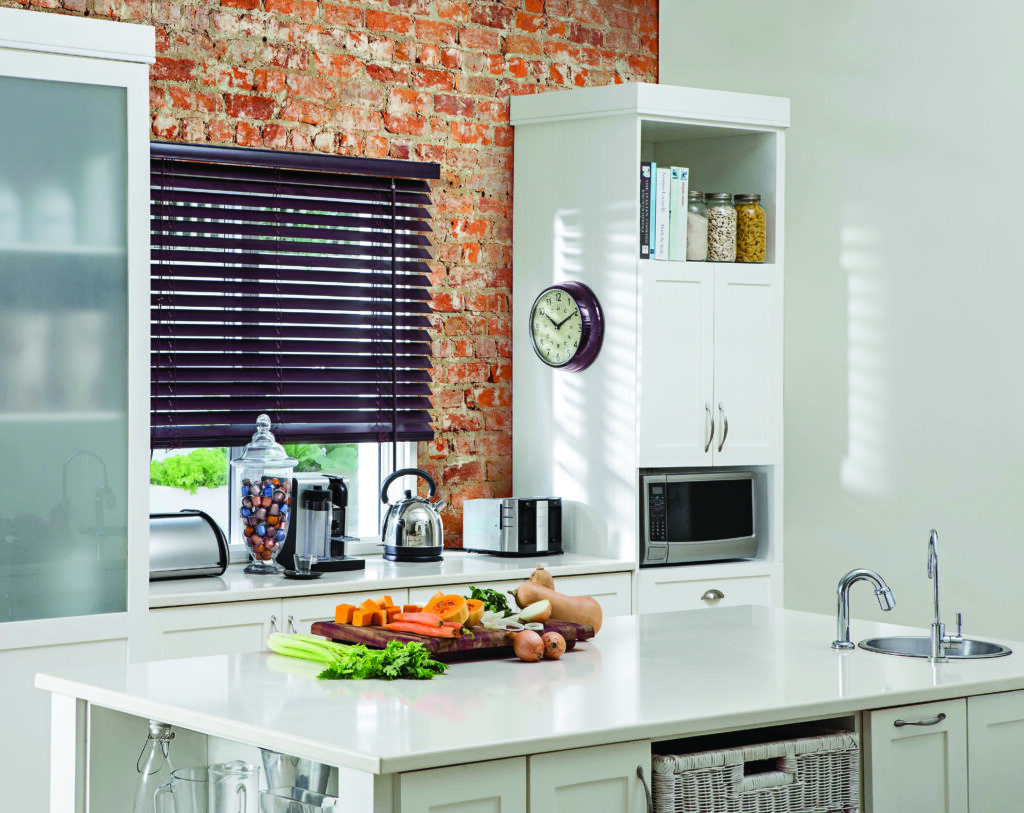 Modern kitchen with white cabinets, Basswood Venetian Blinds, and vegetables on the countertop.